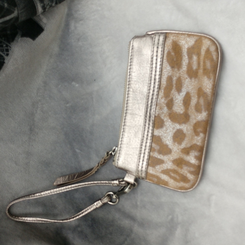 The Sak gold and animal pattern wristlet